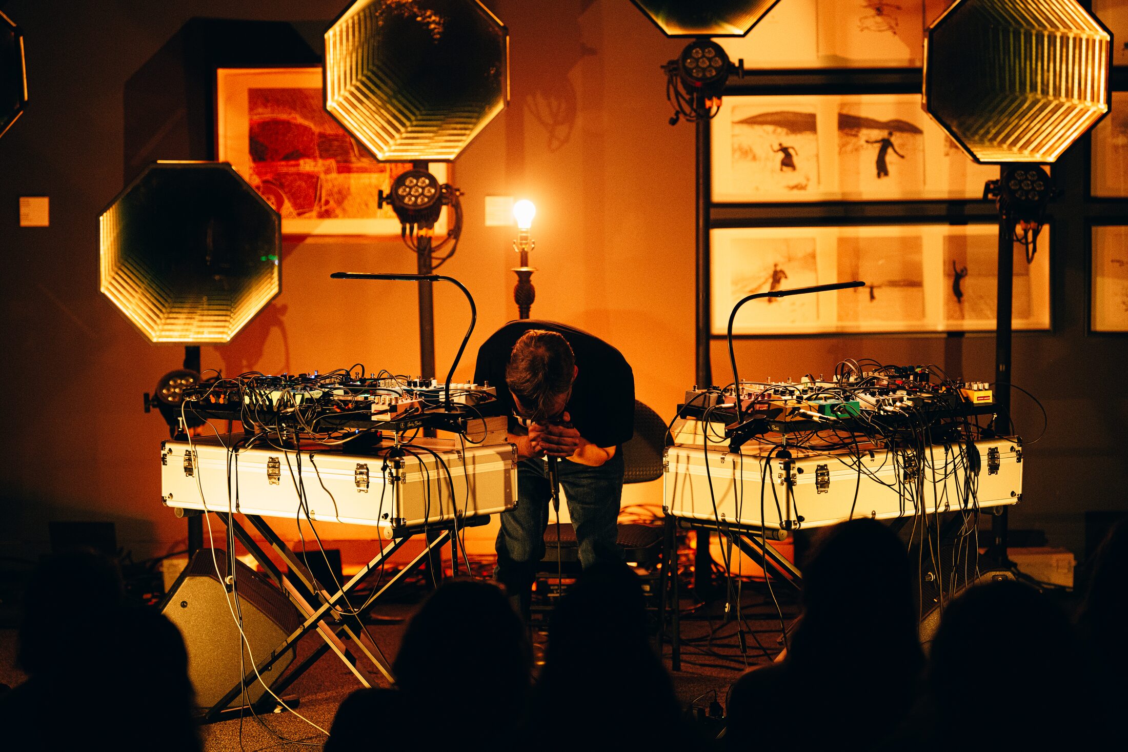 Ulysse Ruel Orchestra en performance : deux tables de pédales de part et d'autre, une lampe allumée derrière